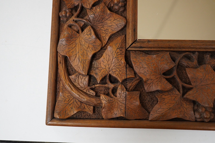 An early 20th century carved mahogany 'leaf, vine and berry' framed mirror, 41x38cm. Condition - good